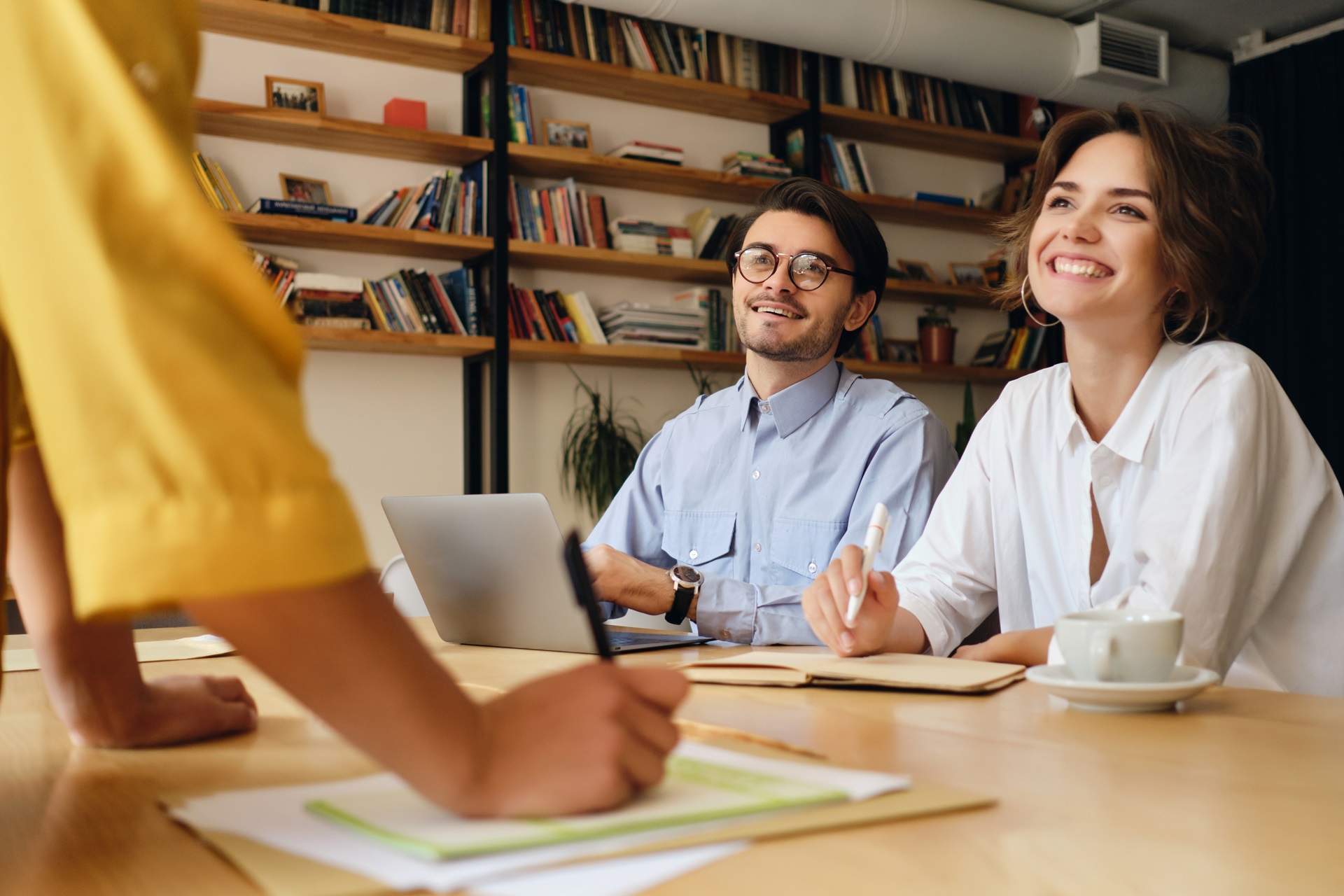 Young attractive business colleagues sitting at the desk with la